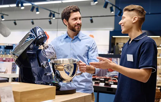 A customer discusses stand mixer features with a knowledgeable sales associate instore